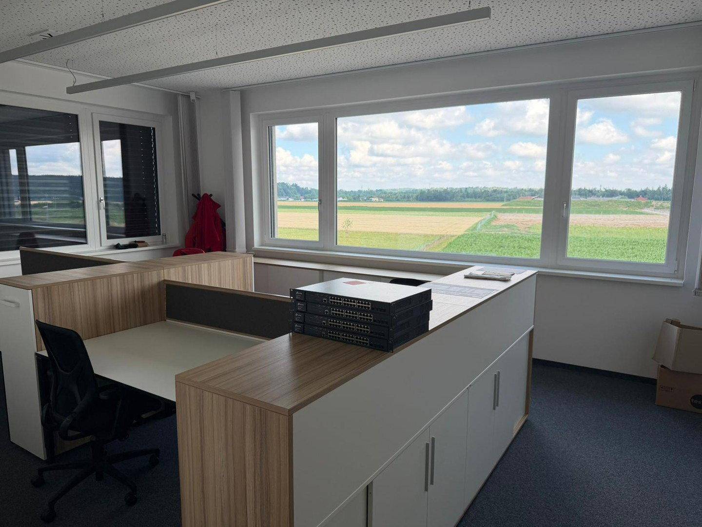 Büro mit mehreren Arbeitsplätzen und einem weiten Blick über die grüne Landschaft.