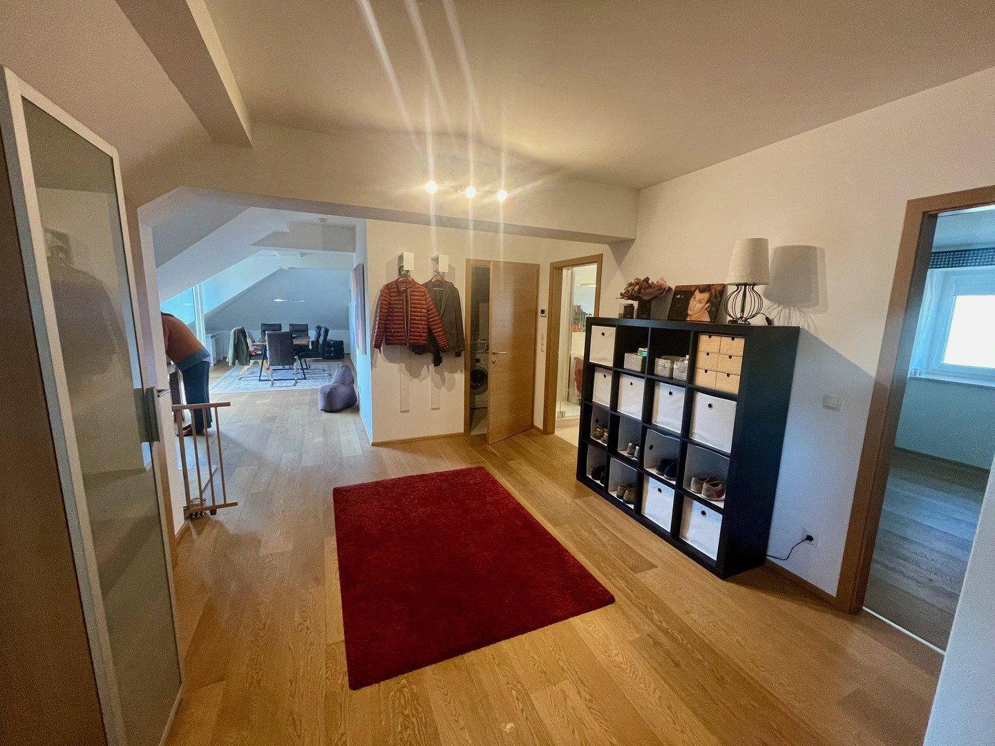 Geräumiger Flur mit Holzboden, Garderobe und praktischem Schuhregal.
