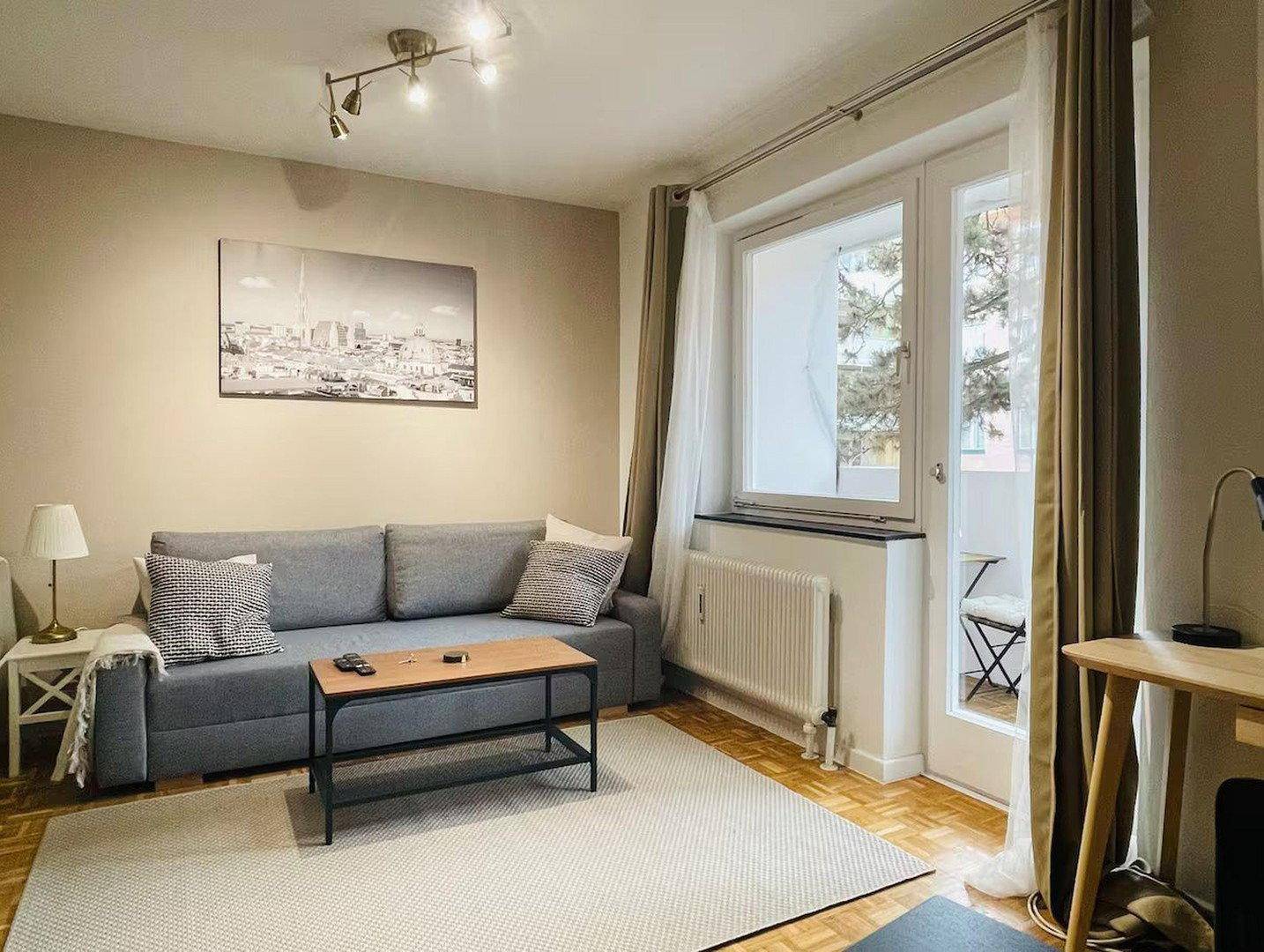 Gemütlicher Wohnbereich mit Sofa, Couchtisch und großem Fenster mit Blick nach draußen.