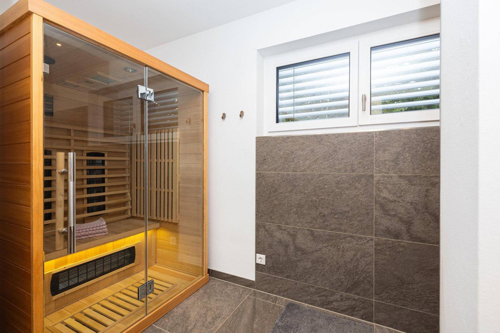 Helles Badezimmer mit Infrarot-Sauna und Fenster, ideal zur Entspannung.