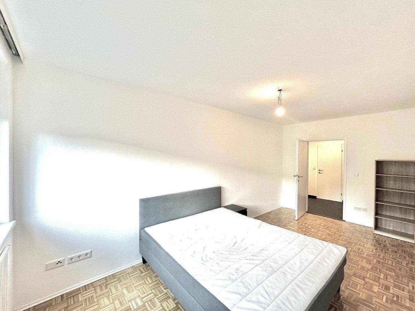 Geräumiges Schlafzimmer mit Parkettboden und viel Platz für individuelle Einrichtung.