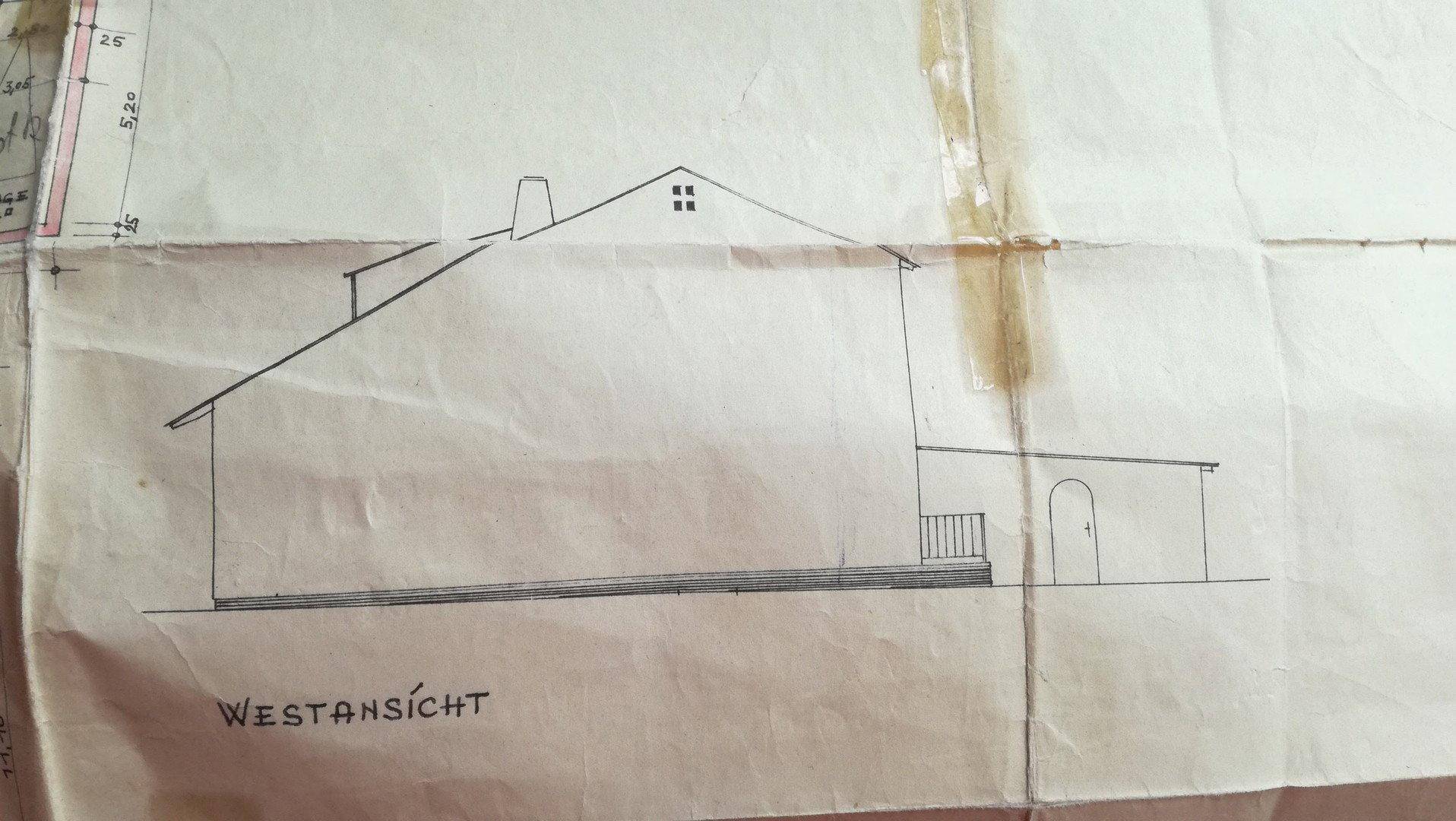 Westansicht des Gebäudes mit Satteldach, kleinem Balkon und traditioneller Architektur.