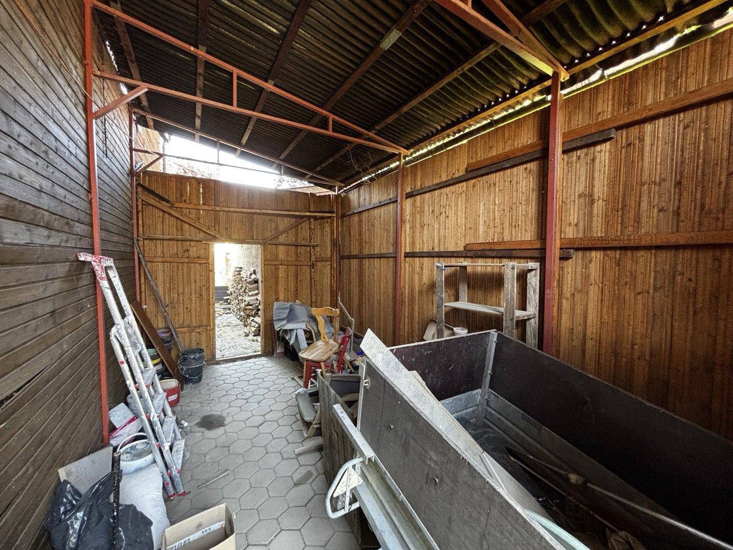 Geräumiger Schuppen oder Lagerraum mit Holzverkleidung und Betonboden.