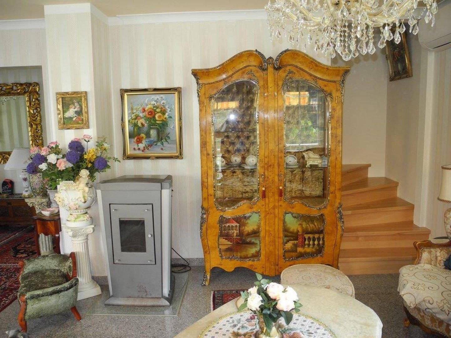 Wohn- und Essbereich mit eleganten Möbeln, Kaminofen und Wendeltreppe.