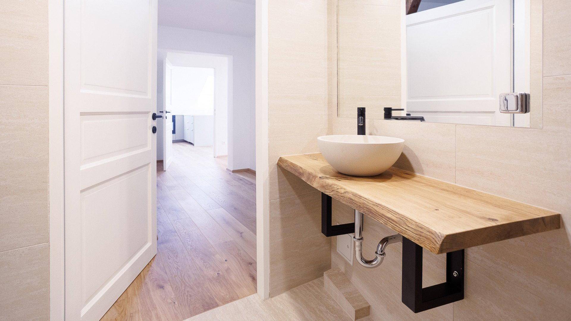 Modernes Badezimmer mit einzigartigem Waschtisch aus Massivholz und stilvollem Aufsatzwaschbecken.