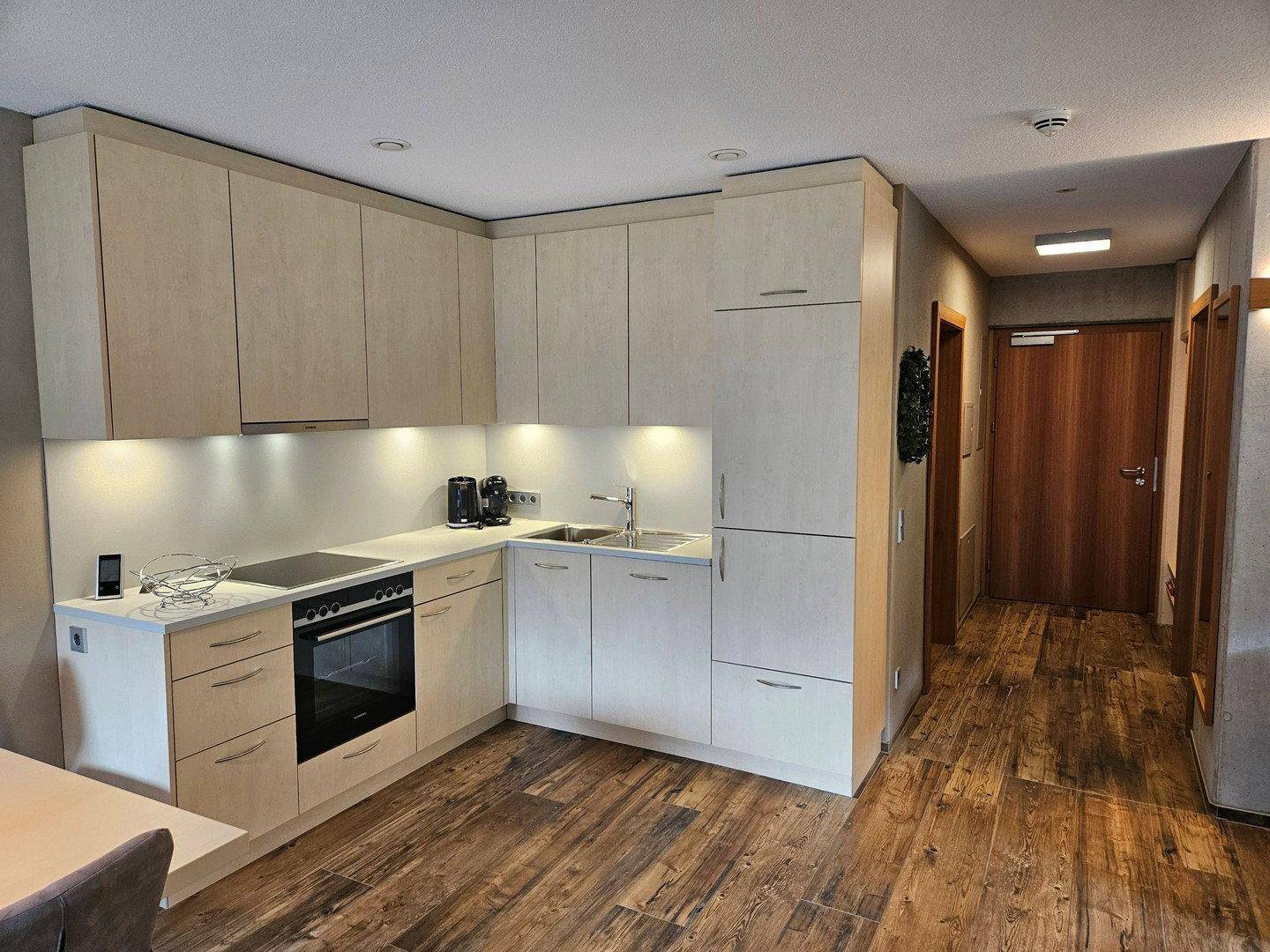 Moderne Einbauküche in hellem Design mit Kochfeld, Backofen und viel Stauraum.