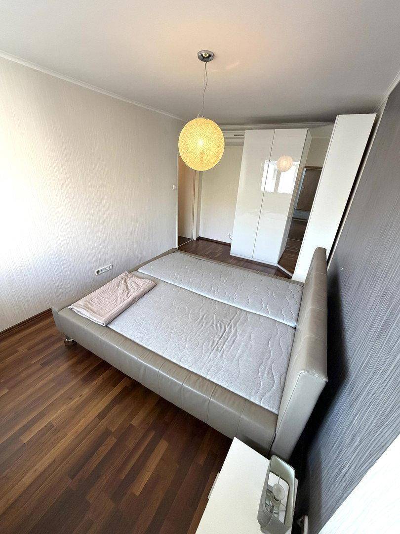 Helles Schlafzimmer mit Doppelbett und weißem Kleiderschrank, ideal für erholsame Nächte.