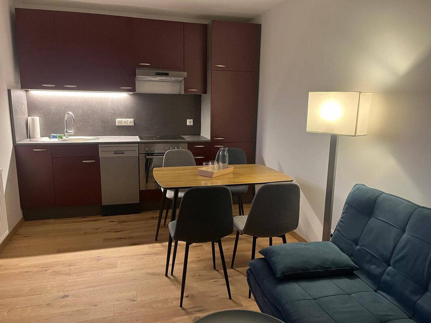 Offener Wohn-Essbereich mit integrierter Küche, Esstisch und gemütlichem Sofa.