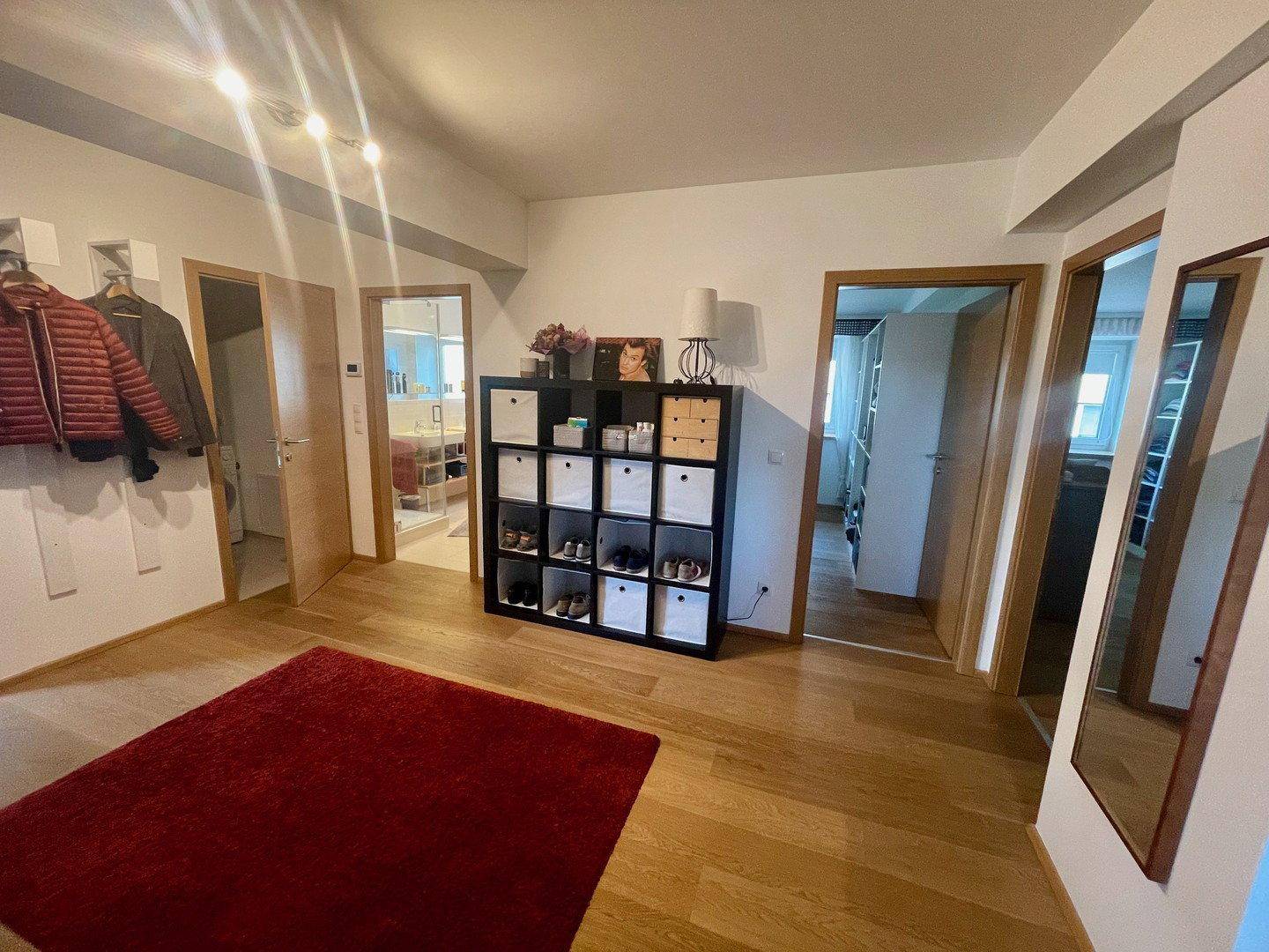 Heller Flur mit Holzboden und mehreren Türen, die zu verschiedenen Räumen führen.