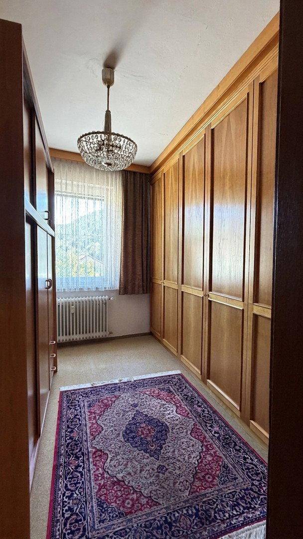 Schlafzimmer mit großen Einbauschränken, Teppichboden und Fenster für natürliches Licht.