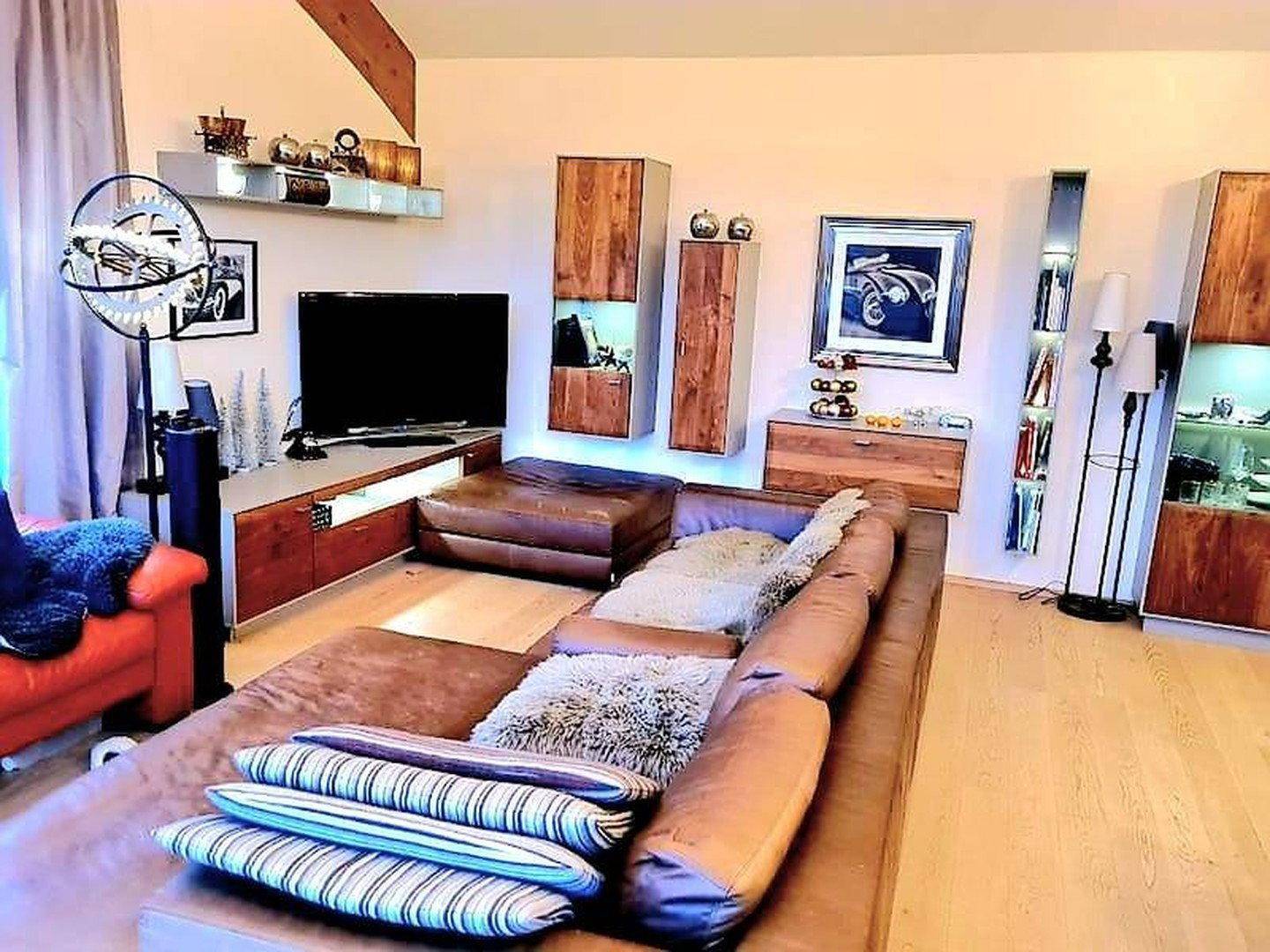 Gemütliches Wohnzimmer mit Ledersofa, Holzelementen und moderner Dekoration.