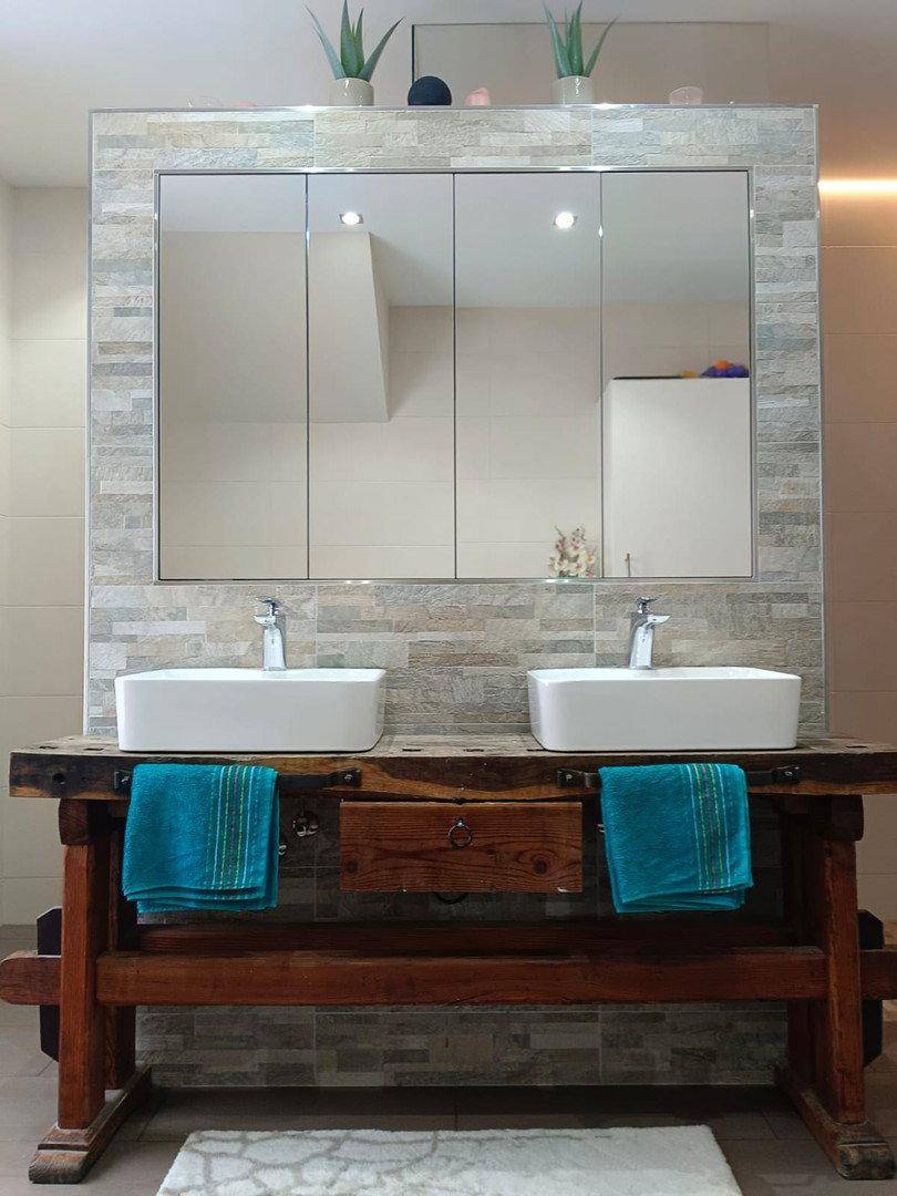 Modernes Badezimmer mit Doppelwaschbecken auf rustikalem Holzunterschrank und großem Spiegelschrank.