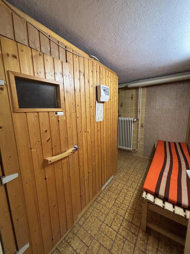 Vorraum zum Saunabereich mit Holzverkleidung und Liegemöglichkeit im Keller.