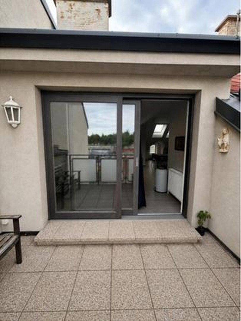 Zugang zur Dachterrasse durch eine große Schiebetür, mit Blick in den Innenraum.