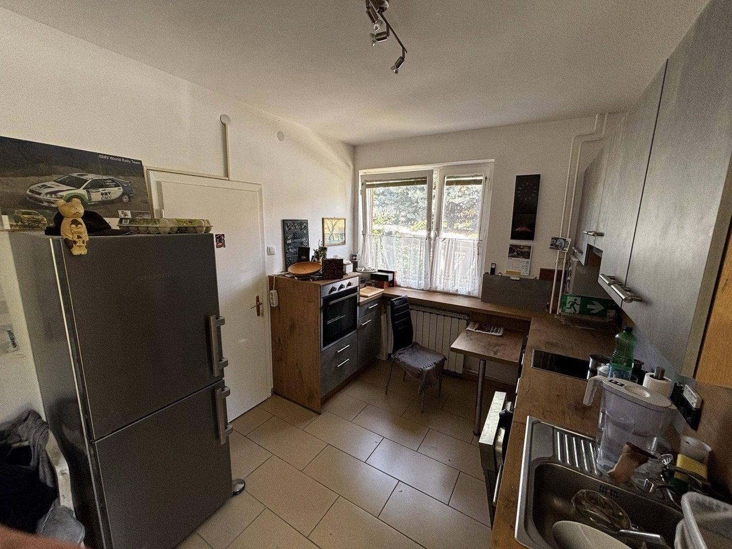 Helle Küche mit Fenster, modernen Geräten und ausreichend Arbeitsfläche.