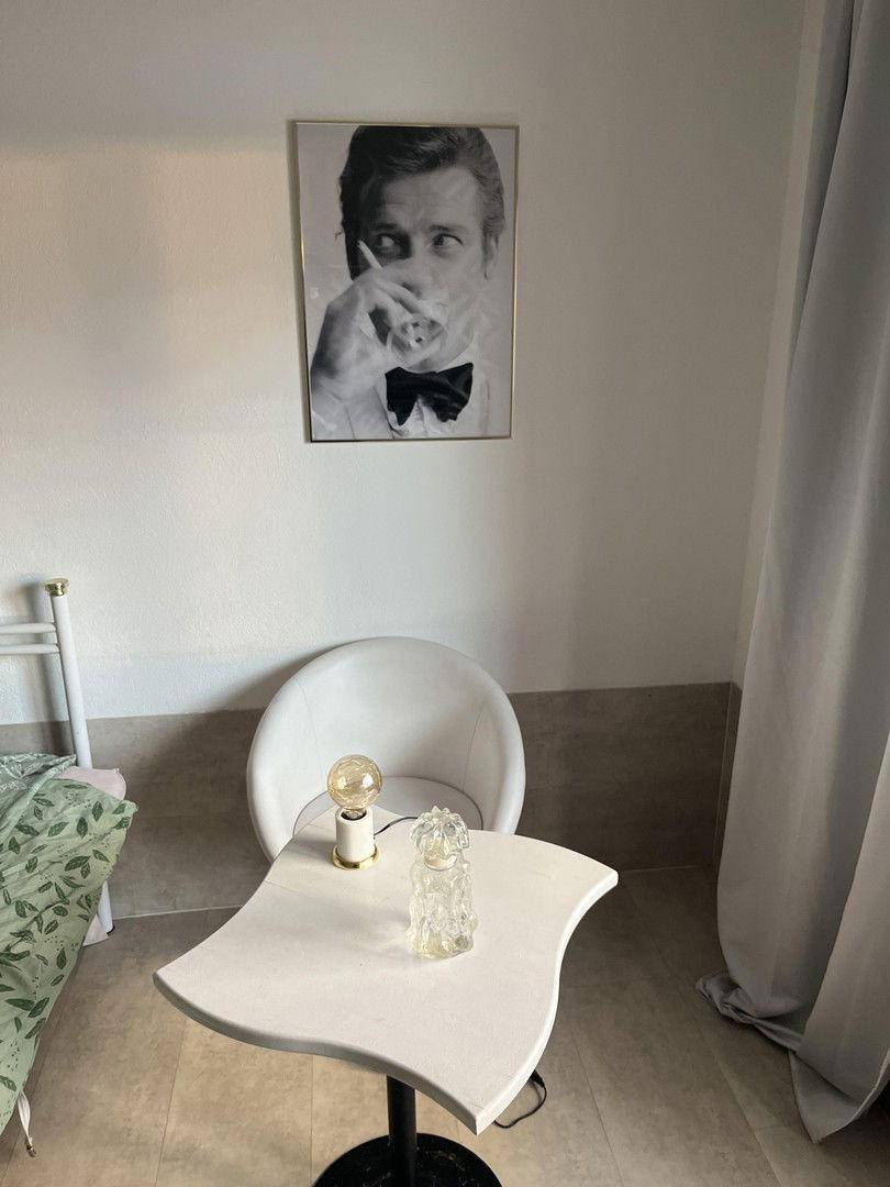 Kleiner Tisch mit Stuhl und dekorativen Elementen in einem hellen Schlafzimmer.