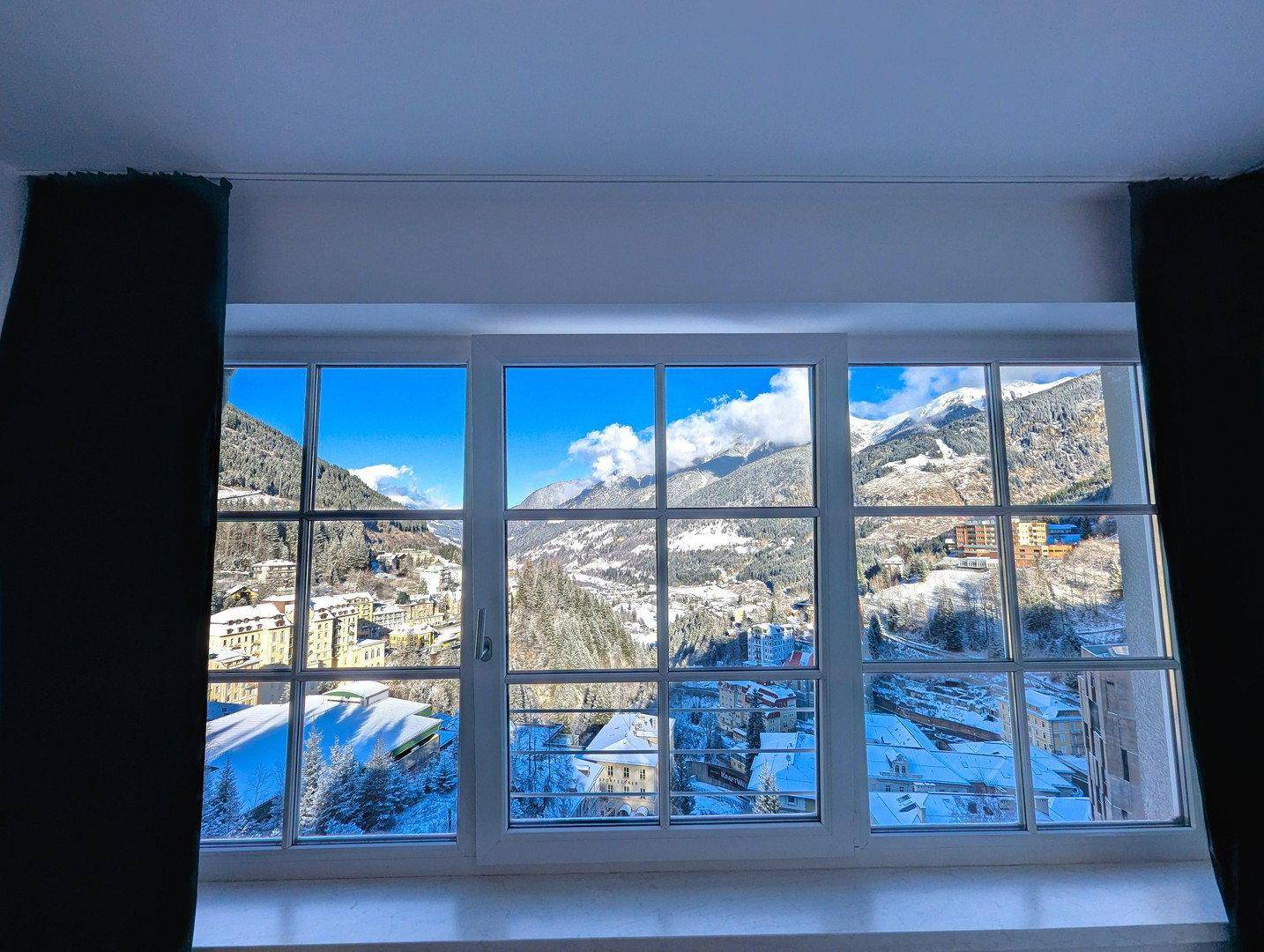 Schlafzimmerfenster mit beeindruckendem Blick auf die schneebedeckten Berge und das winterliche Panorama.
