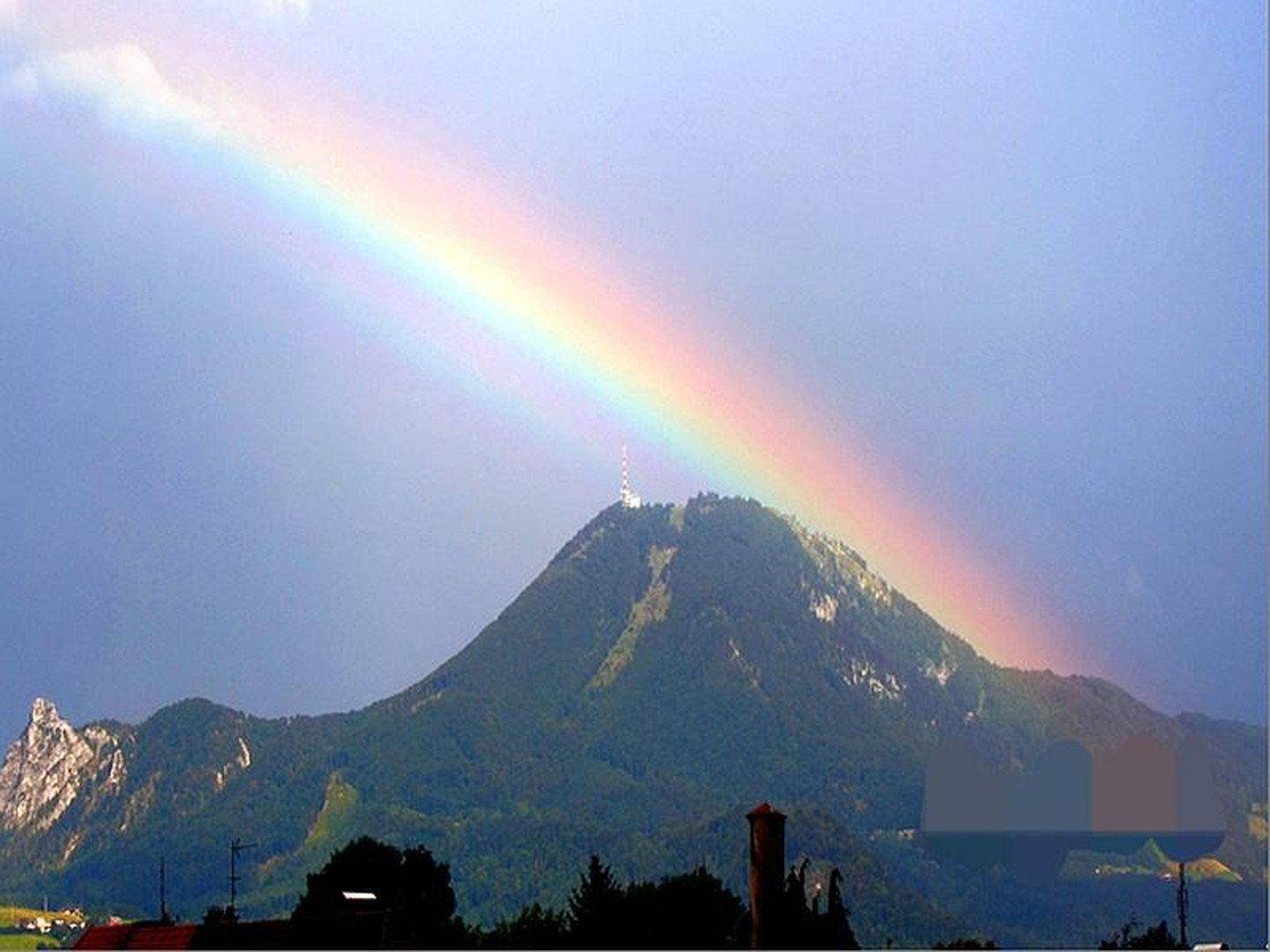 Malerischer Bergblick mit Regenbogen über der Landschaft.