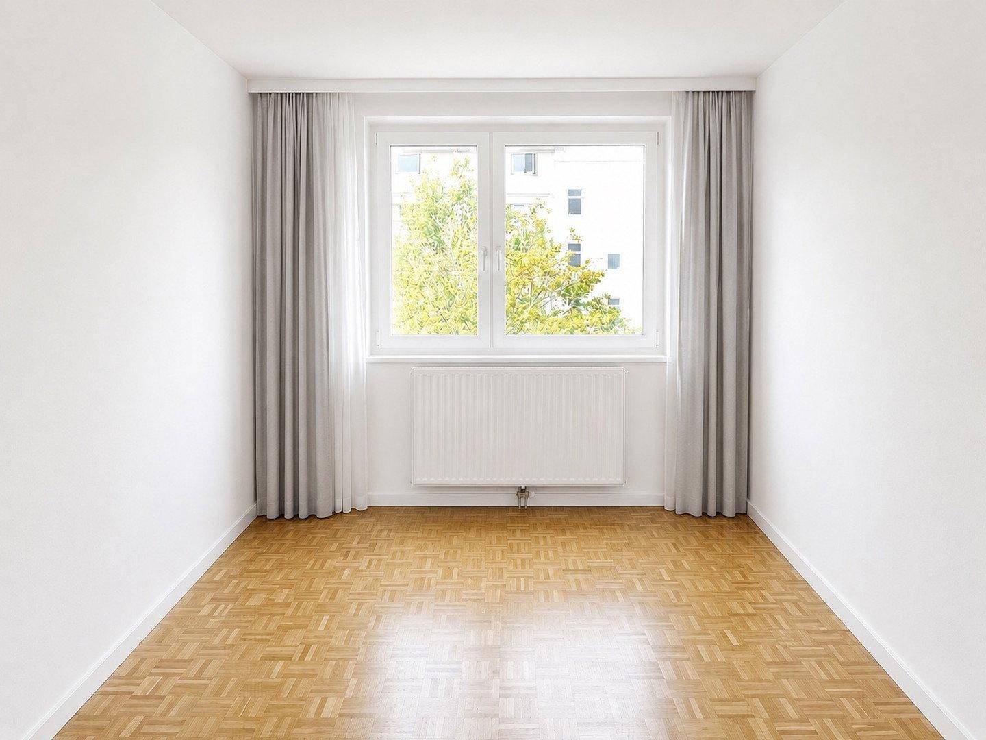 Heller, leerer Raum mit Parkettboden und großem Fenster, bereit zur individuellen Gestaltung.