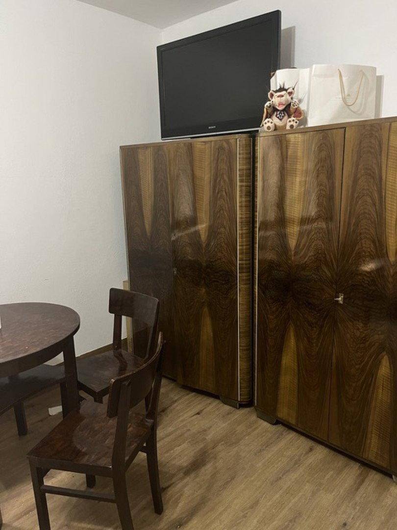 Detailansicht von zwei eleganten Vintage-Kleiderschränken und einem Fernseher in einem Schlafzimmer.