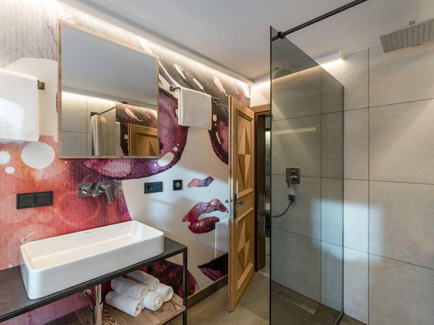 Modernes Badezimmer mit begehbarer Dusche, stilvoller Wandgestaltung und Einzelwaschbecken.