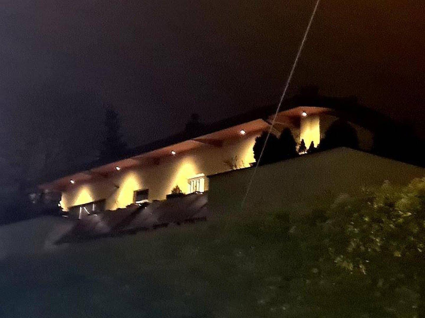 Das moderne Gebäude bei Nacht, beleuchtet von warmen Lichtern, die die Architektur hervorheben.