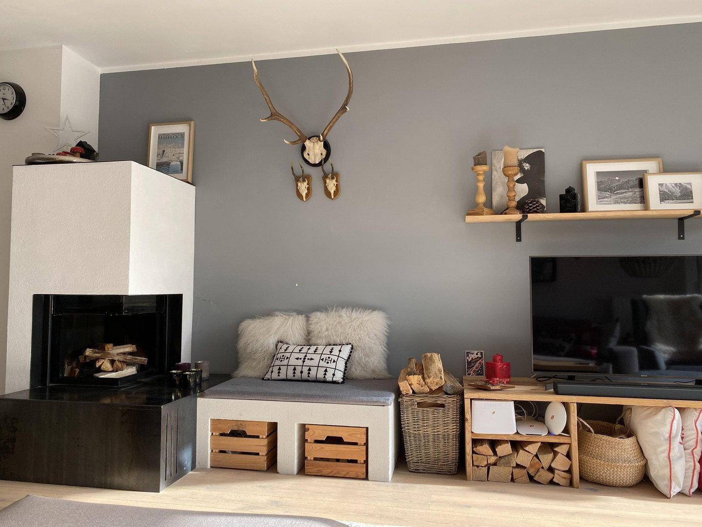 Wohnzimmer mit modernem Kamin, TV-Bereich und alpiner Dekoration.