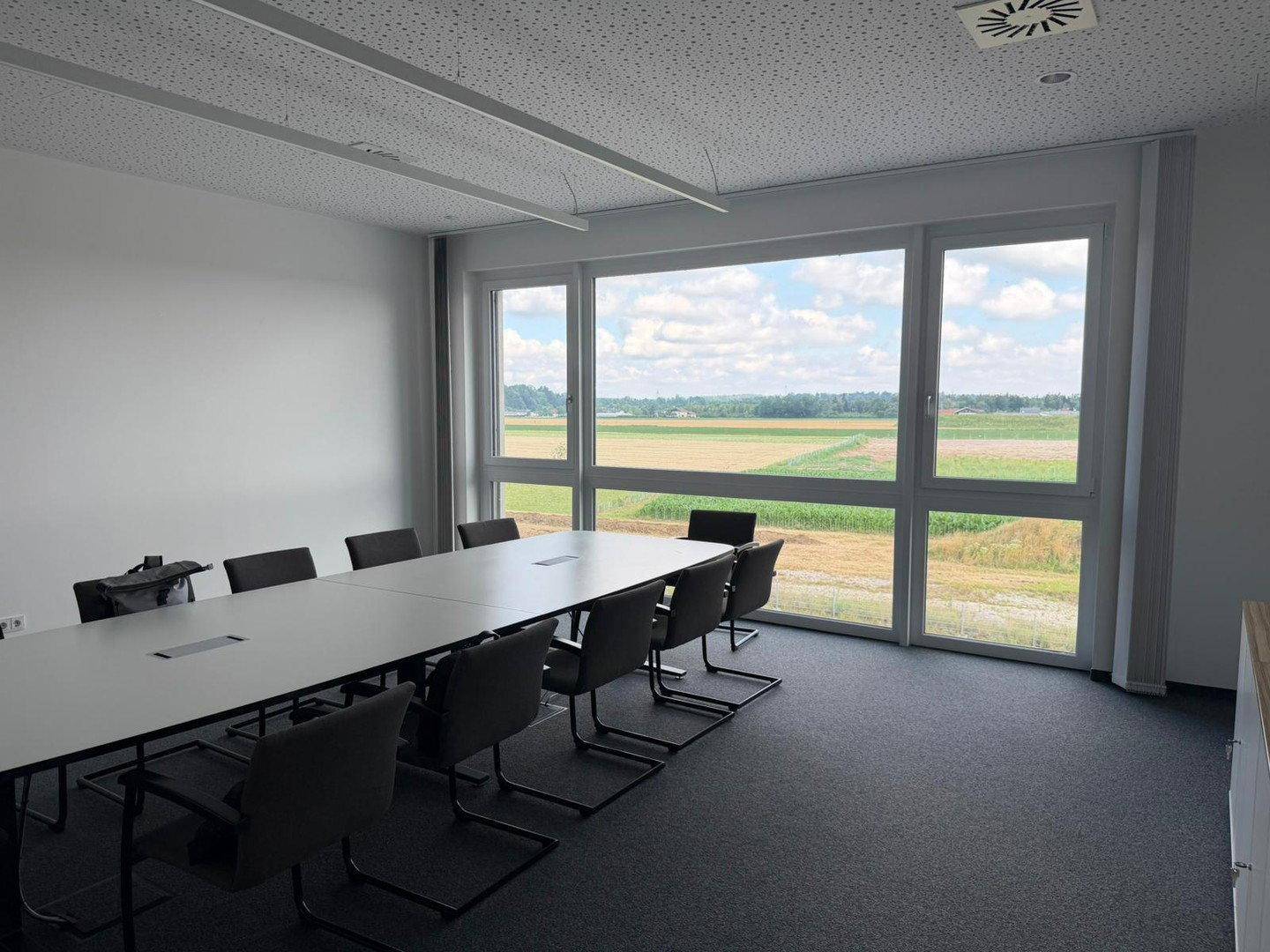 Heller Konferenzraum mit weitem Blick über die Landschaft durch große Fenster.
