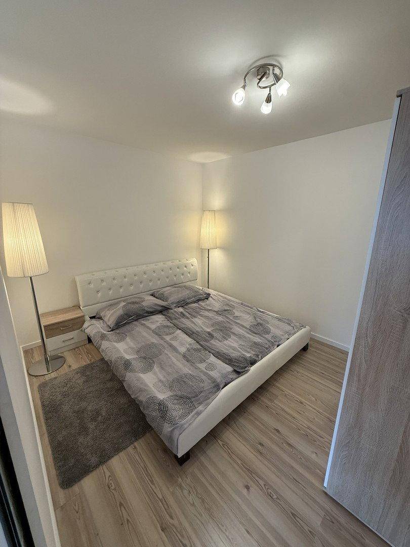Gemütliches Schlafzimmer mit Doppelbett, Nachttischen und hellem Laminatboden.