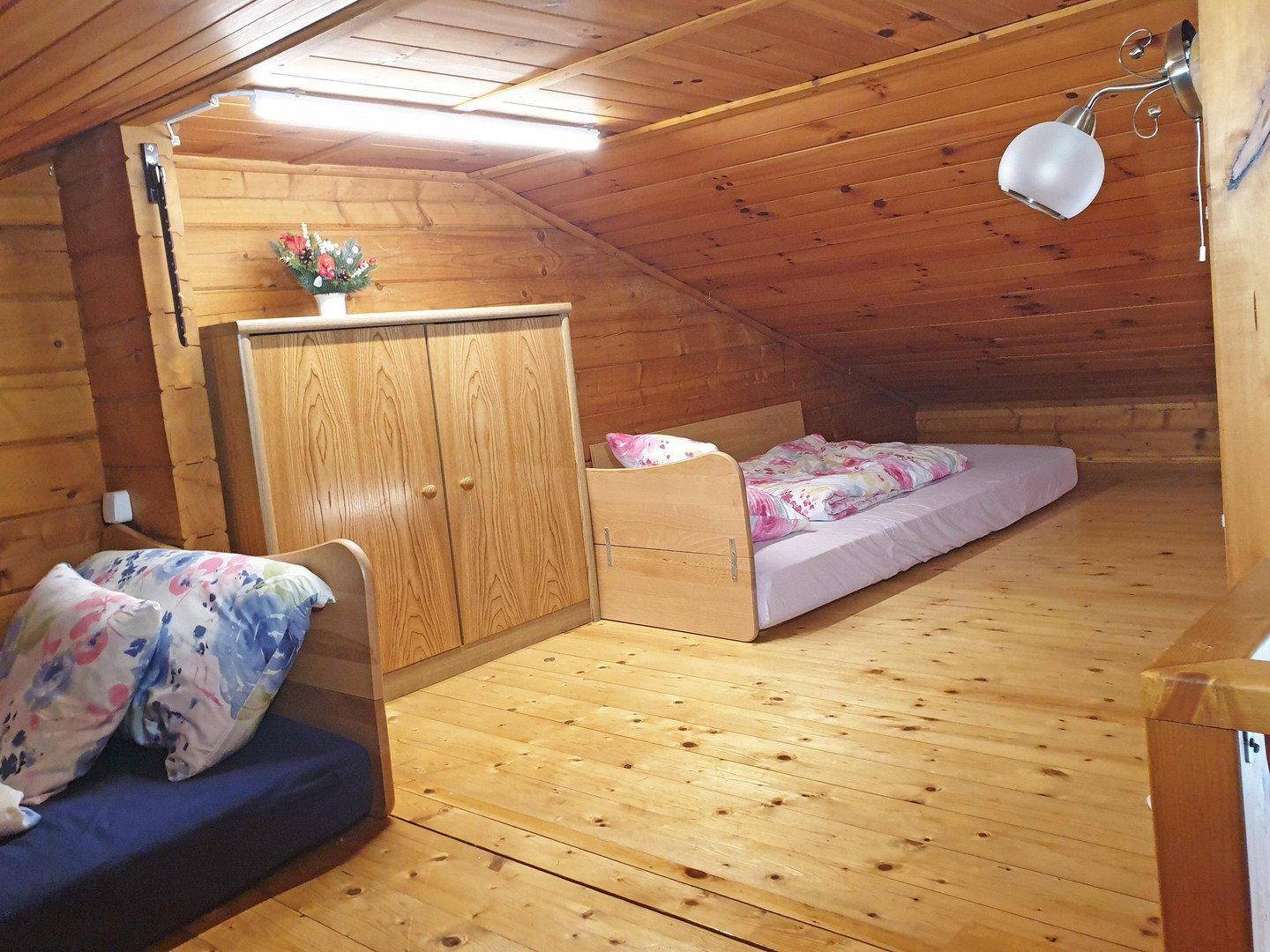 Weiterer Schlafbereich auf der Galerie mit Holzboden und Dachschräge, ideal für Gäste.