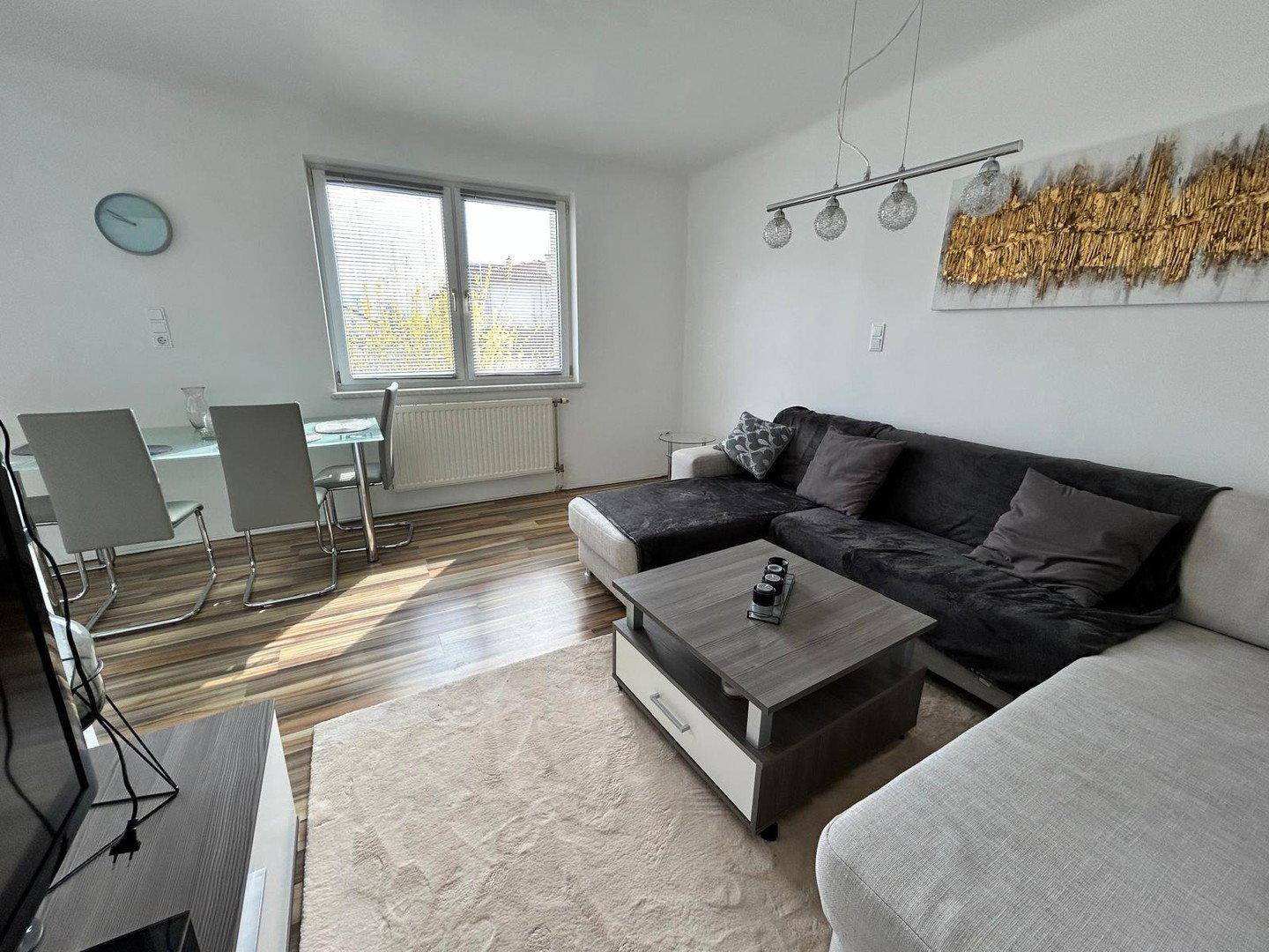 Gemütlicher Wohnbereich mit großem Sofa, Couchtisch und Blick auf den Essbereich.