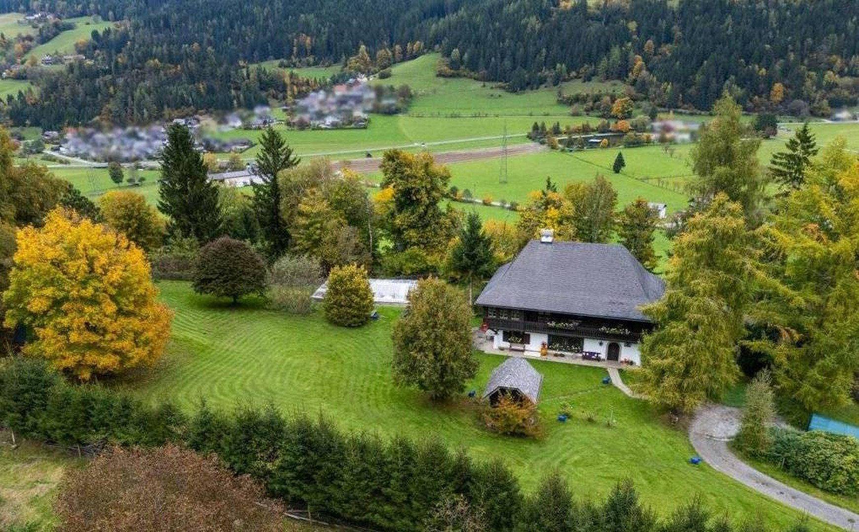 Luftaufnahme des Anwesens mit großem Garten, Haus und umliegender grüner Landschaft.