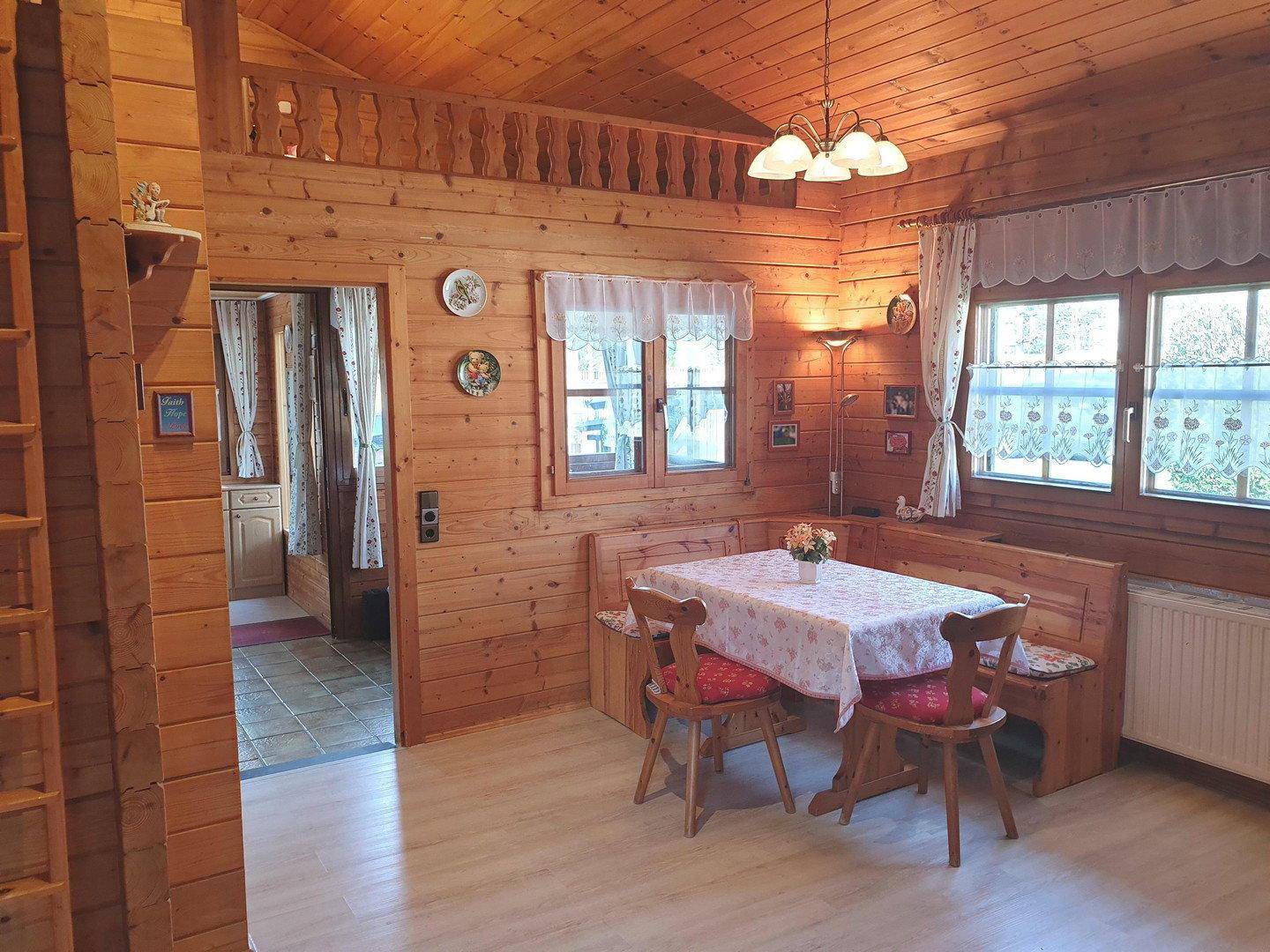 Rustikaler Wohn-Essbereich mit Holzbalkendecke, Holzwänden und Esstisch mit Eckbank.
