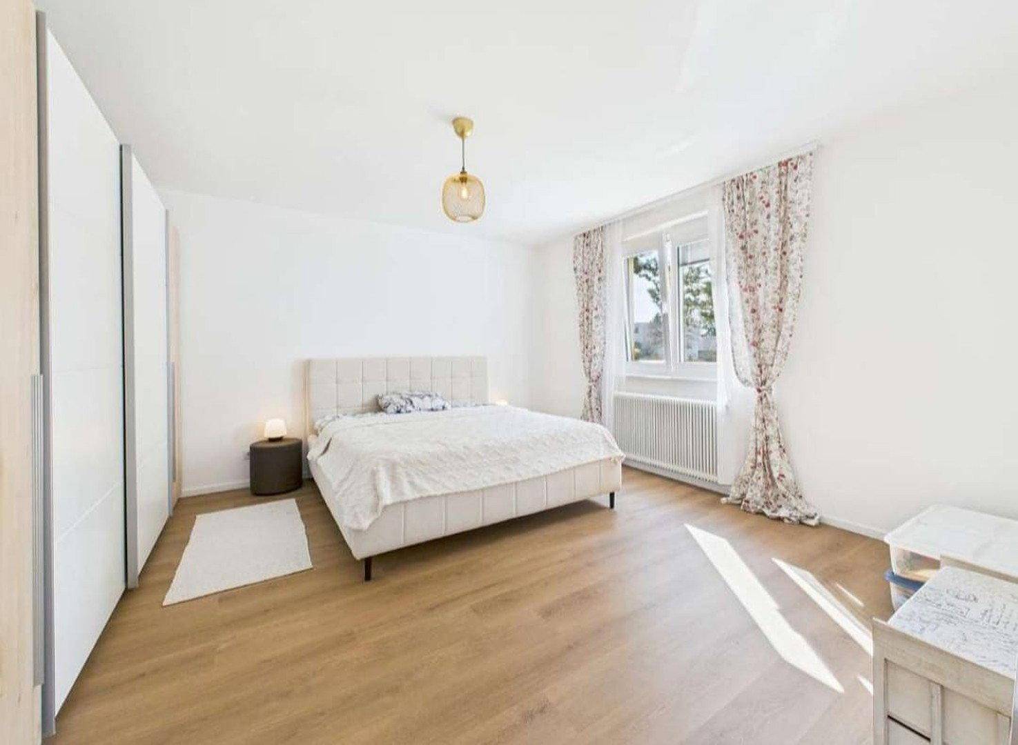 Geräumiges Schlafzimmer mit Doppelbett, Kleiderschrank und viel Tageslicht.