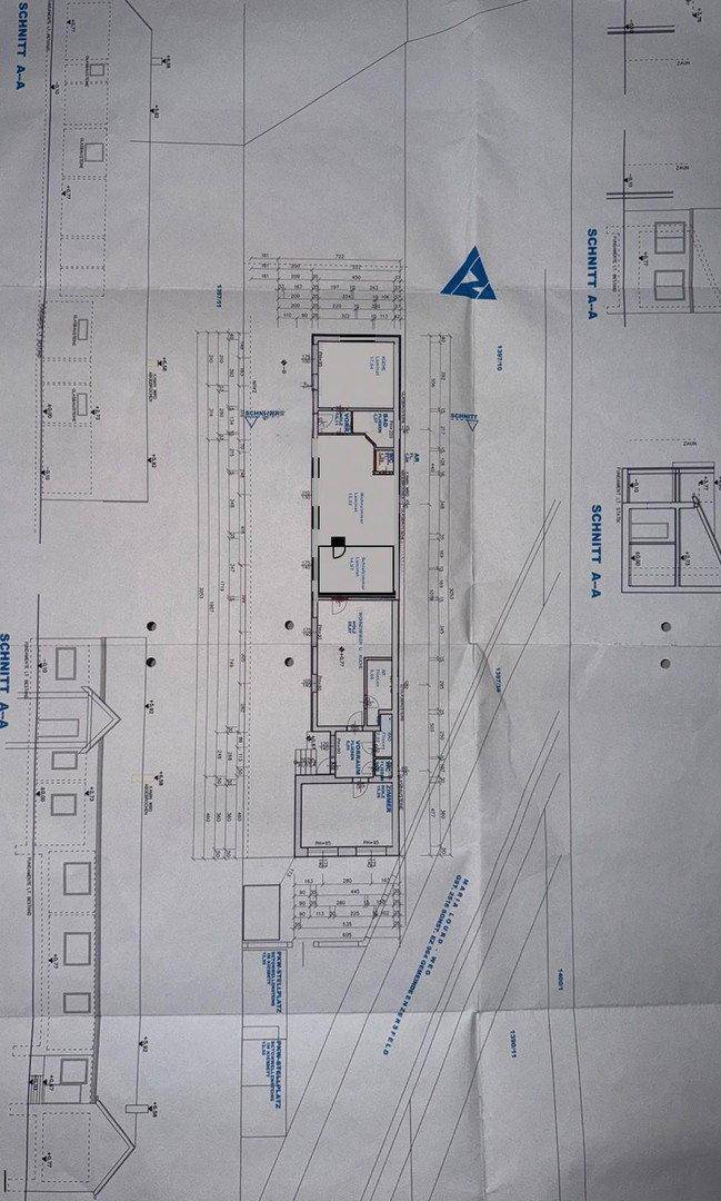 Detaillierter Grundriss des Gebäudes mit verschiedenen Schnitten und Maßen.