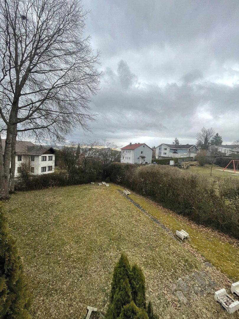 Großer Gartenbereich mit Rasenfläche und Blick auf die umliegenden Häuser.
