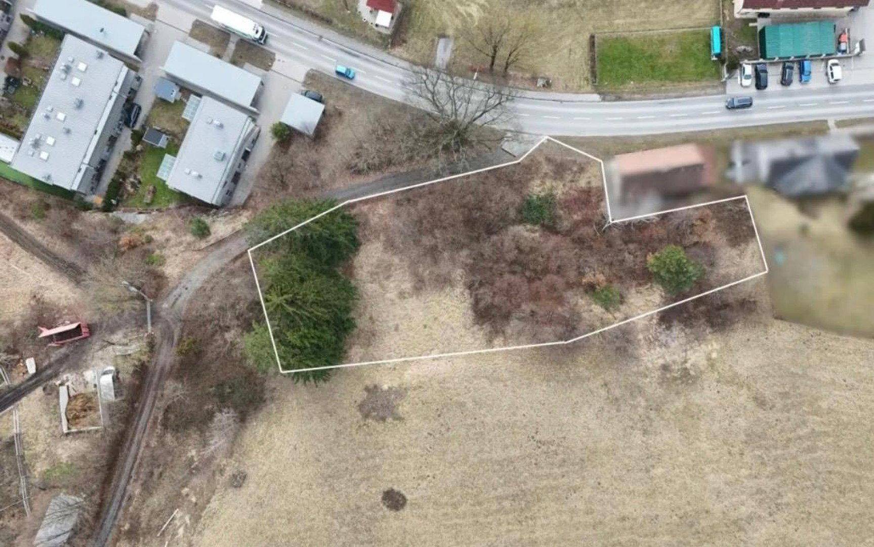 Nahaufnahme des umrandeten Grundstücks aus der Vogelperspektive, angrenzend an eine Straße.