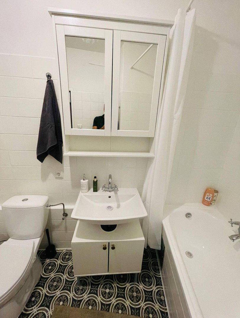 Modernes Badezimmer mit Waschbecken, Toilette, Spiegelschrank und Badewanne.