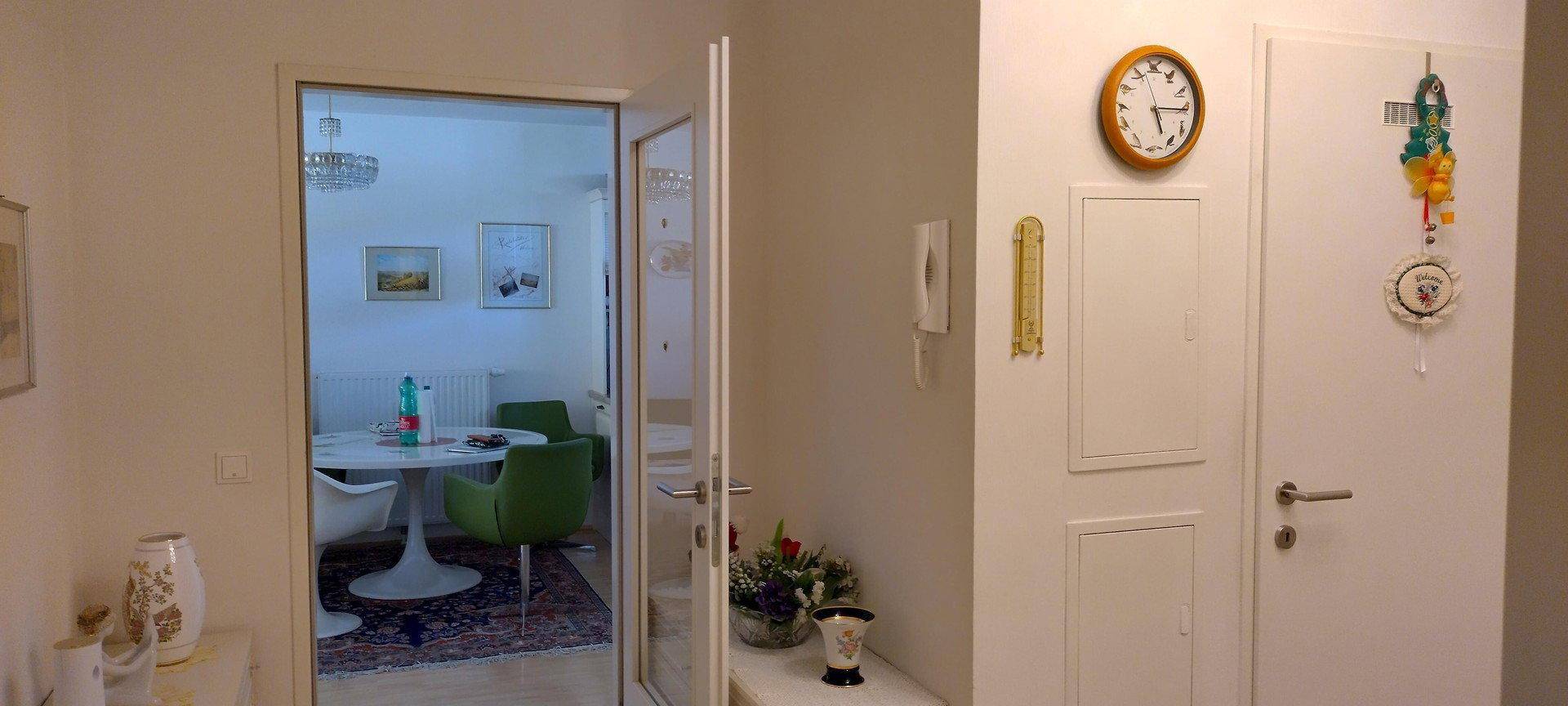 Heller Flur mit Blick in einen angrenzenden Essbereich, ausgestattet mit Fliesenboden.