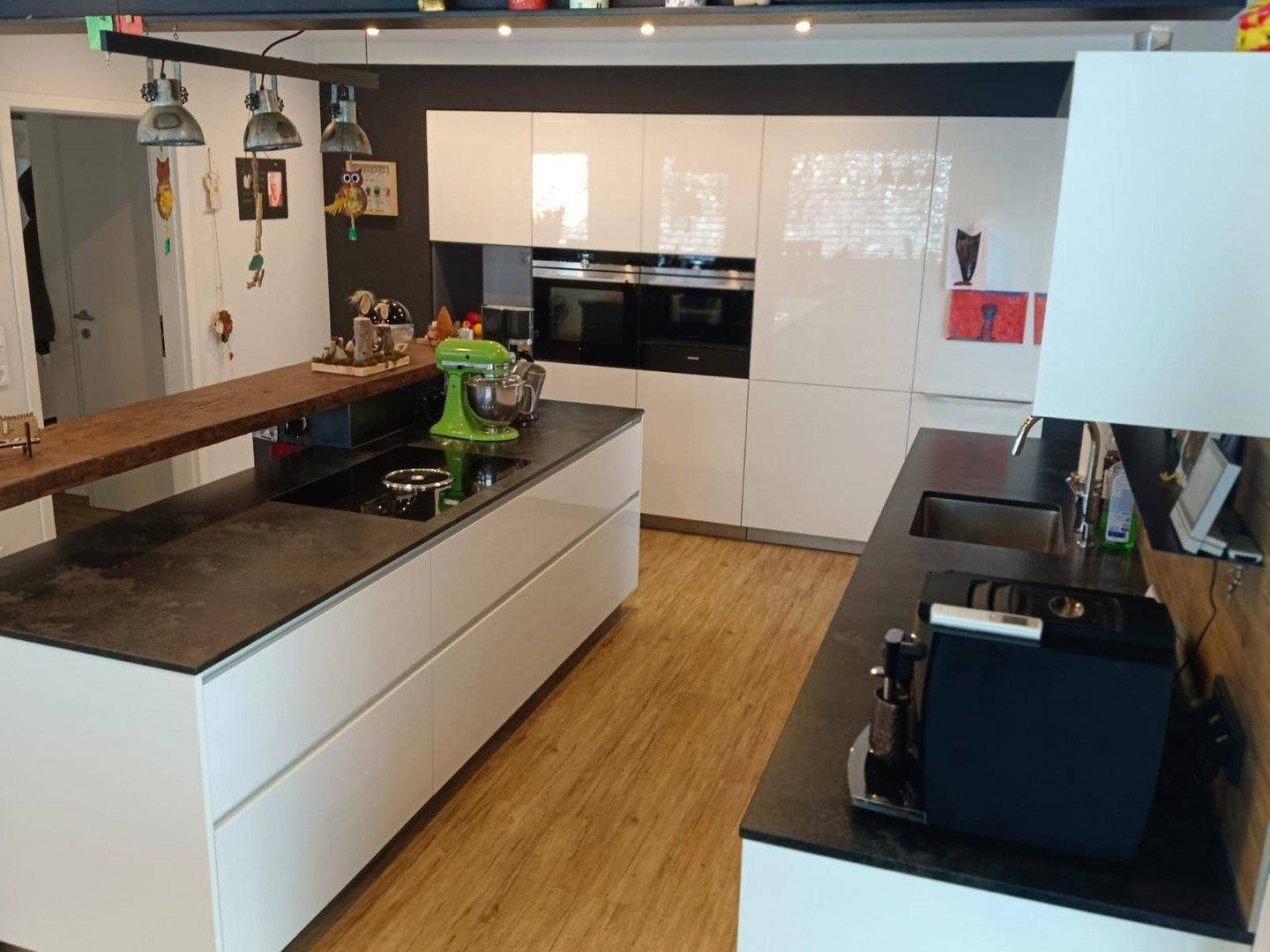Moderne Küche mit Kücheninsel, Induktionskochfeld und integrierten Siemens-Geräten.