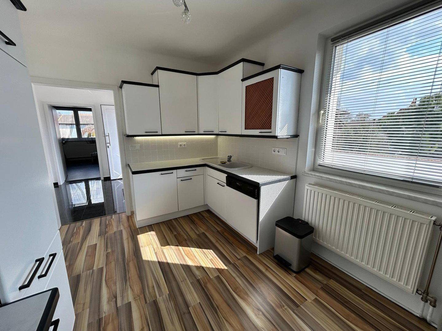 Küchenzeile mit Spüle, Geschirrspüler und Fenster, das viel Licht hereinlässt.