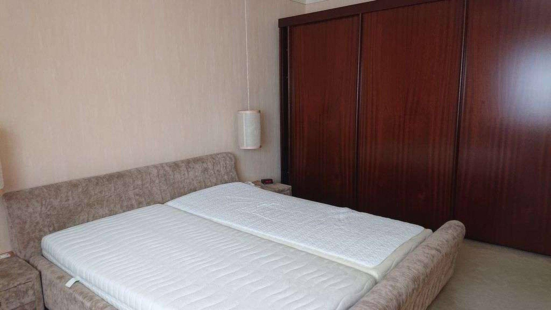 Schlafzimmer mit Doppelbett, Einbauschränken und Teppichboden.