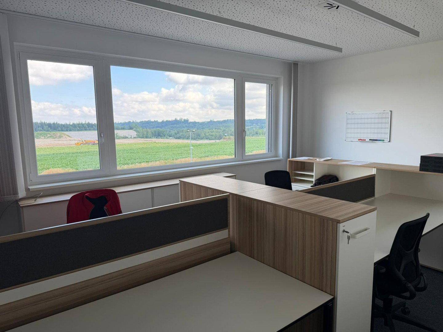 Modernes Büro mit mehreren Arbeitsplätzen und einem weiten Blick auf die umliegende Natur.