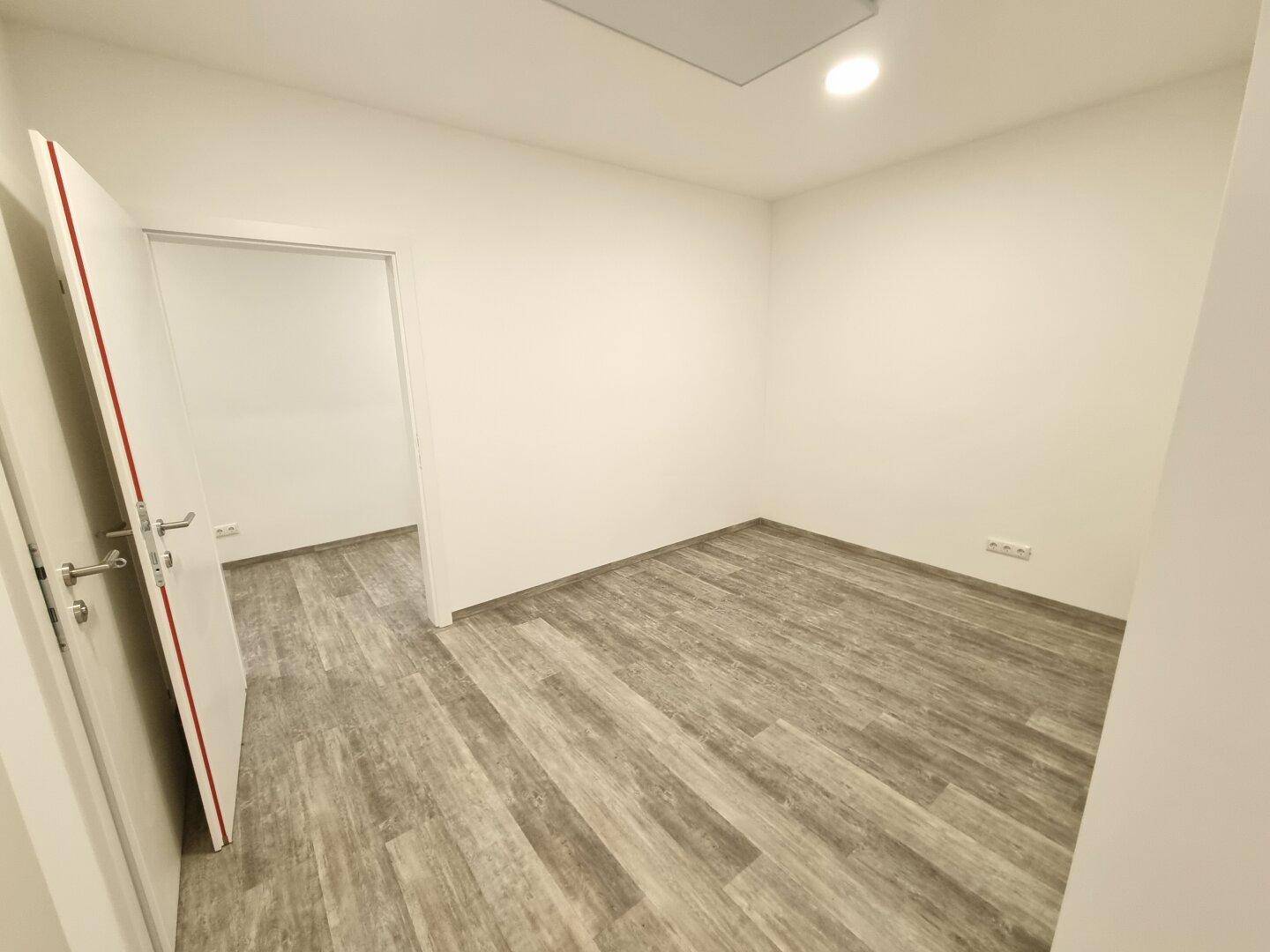 Kleiner, heller Raum mit modernem Bodenbelag, ideal als Büro oder Lagerfläche.
