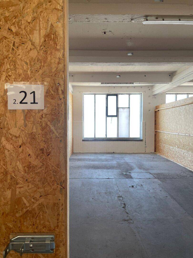 Leerer Raum mit OSB-Wänden, Betonboden und einem Fenster, bereit für die Nutzung.