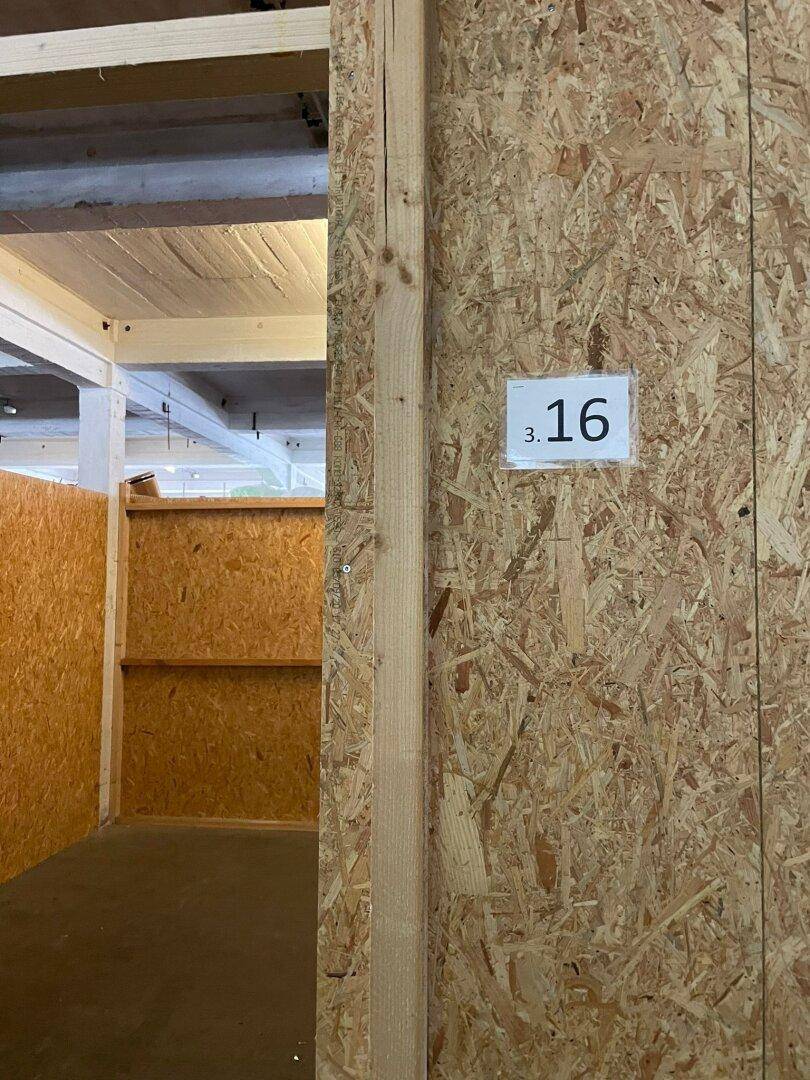 Blick in einen Lagerbereich mit OSB-Wänden und sichtbaren Deckenbalken.