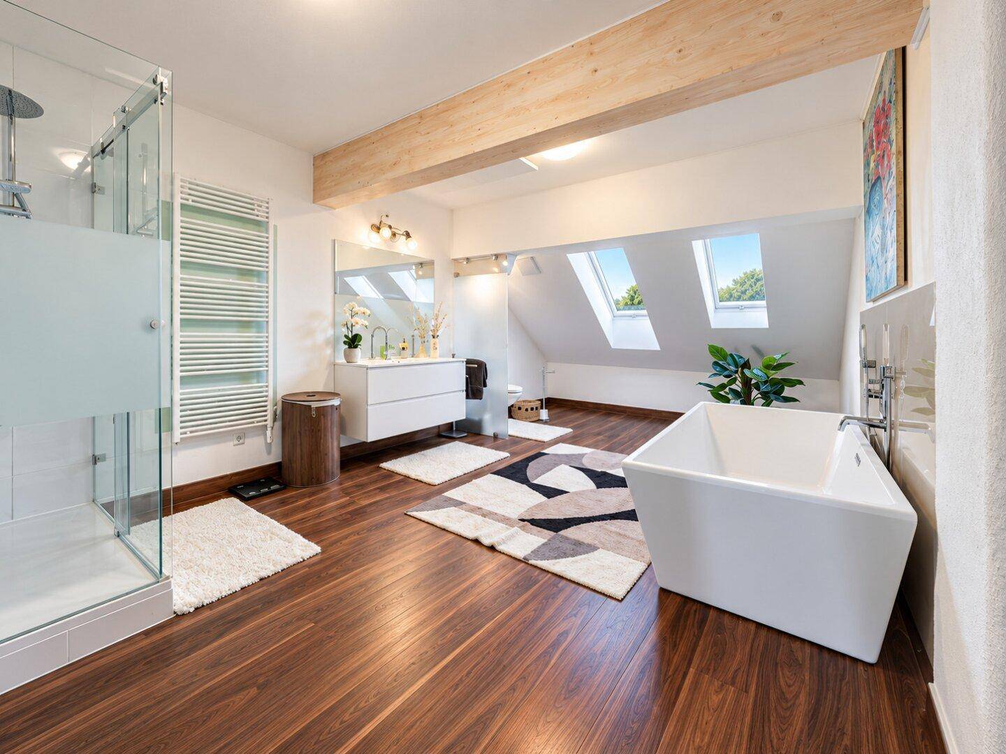 Modernes Badezimmer mit freistehender Badewanne, begehbarer Dusche und Dachfenstern.