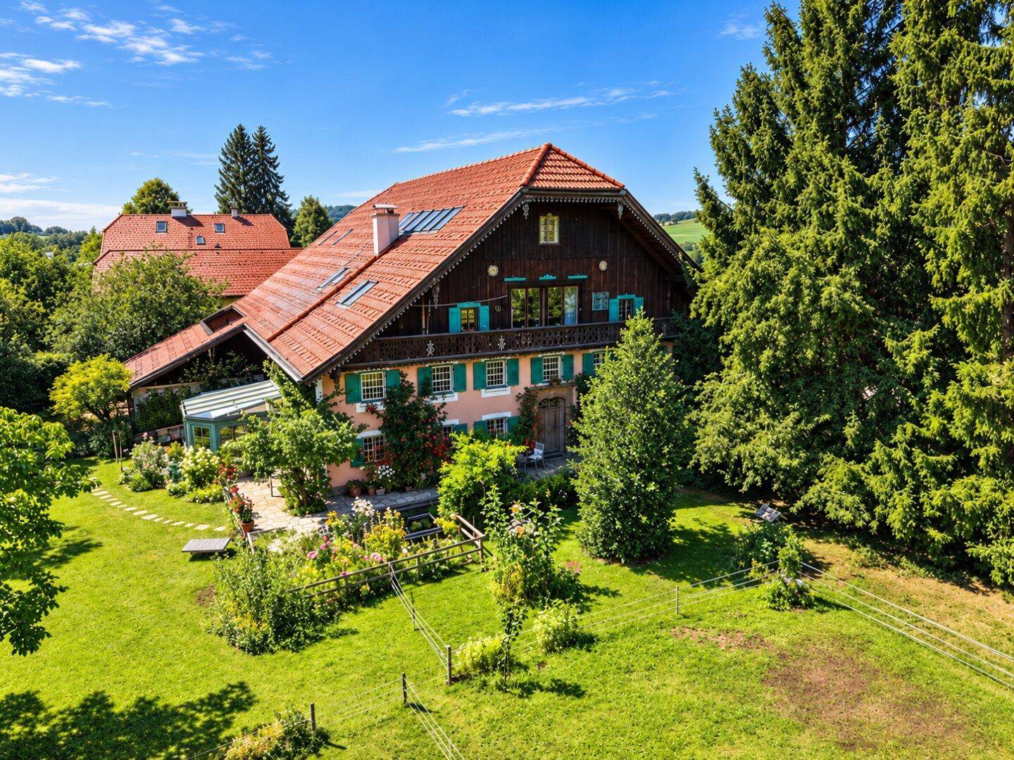 Traditionelles Landhaus mit großem Garten, altem Baumbestand und grüner Umgebung.