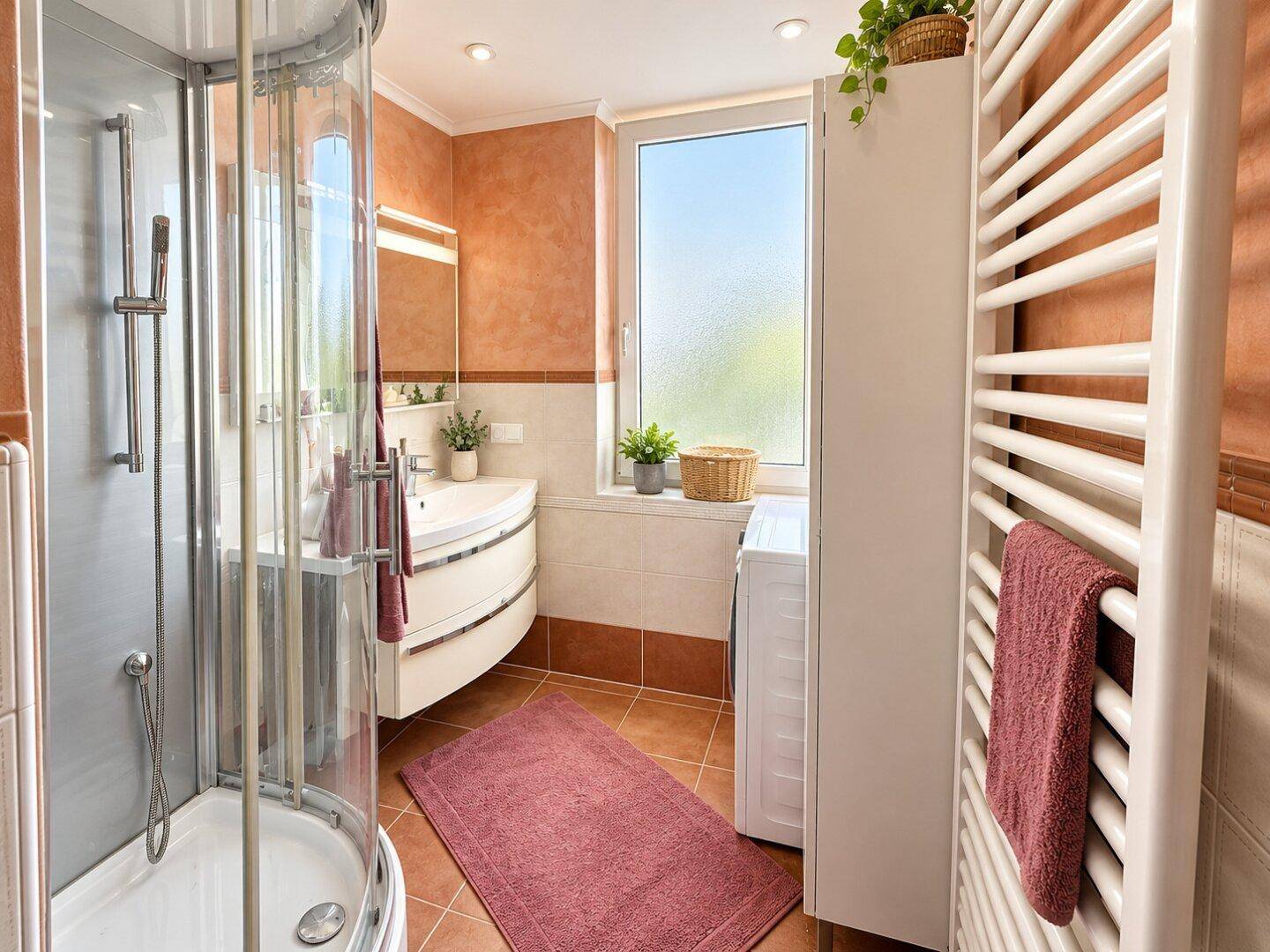 Modernes Badezimmer mit Duschkabine, Waschbecken und beheiztem Handtuchhalter.