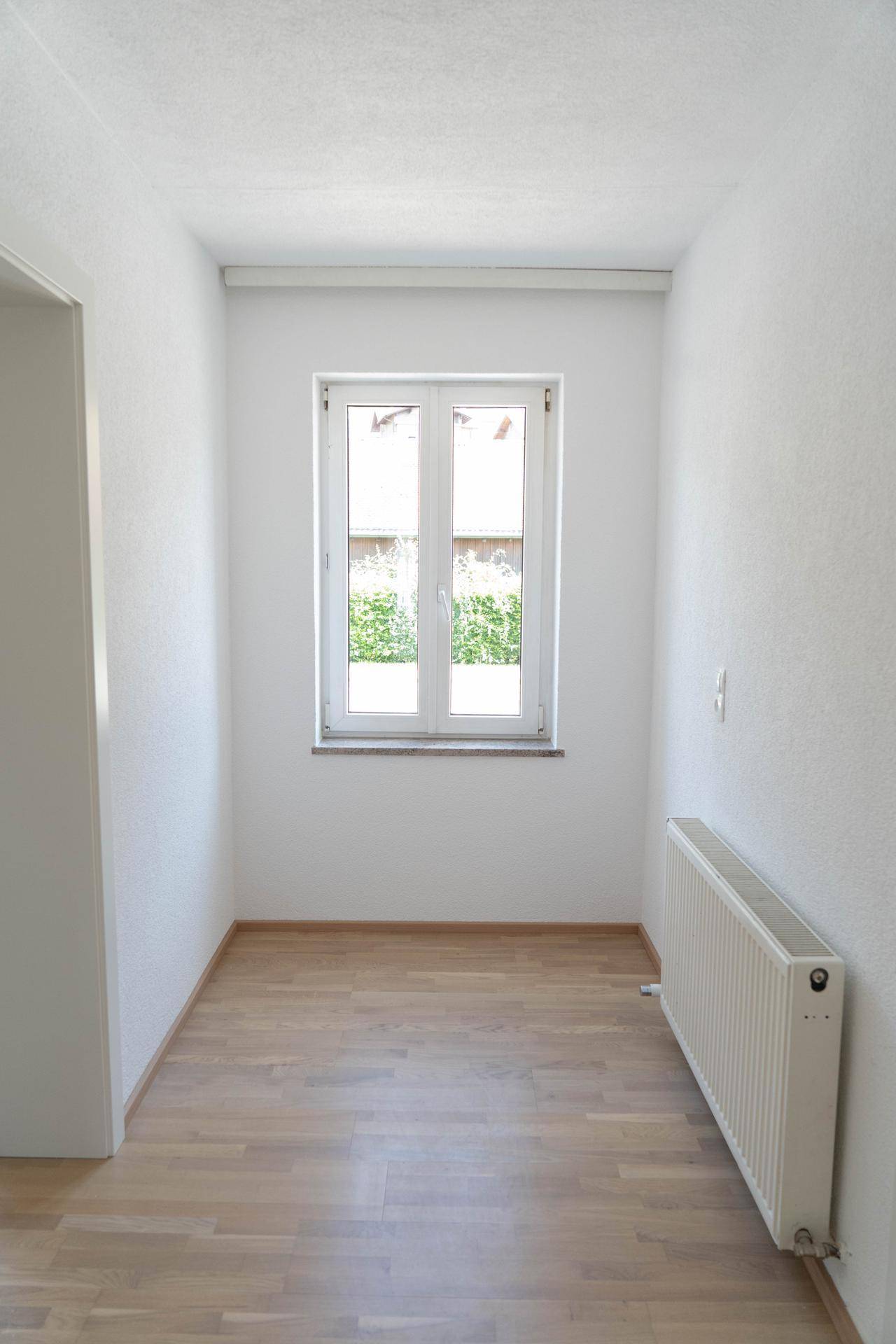 Kleiner, heller Raum mit Fenster und Heizkörper, ideal als Büro oder Abstellraum nutzbar.